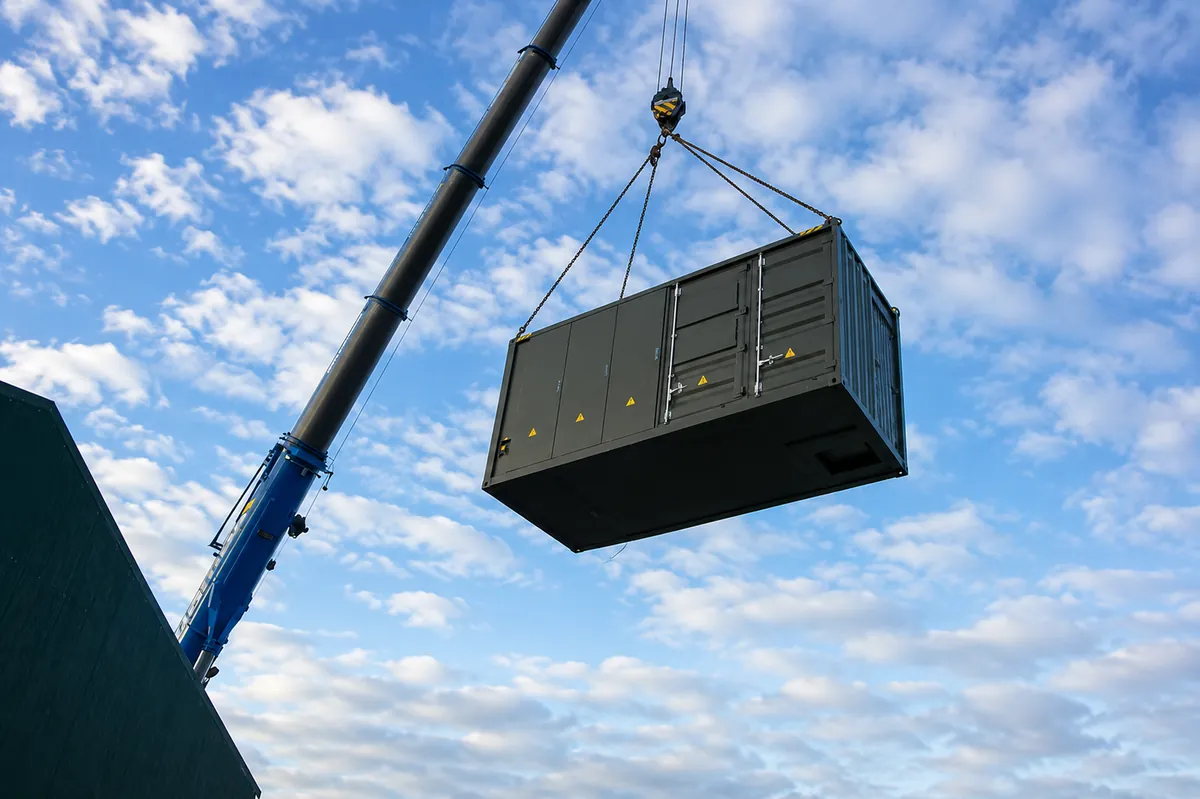 Containerised battery energy storage unit being lifted into position